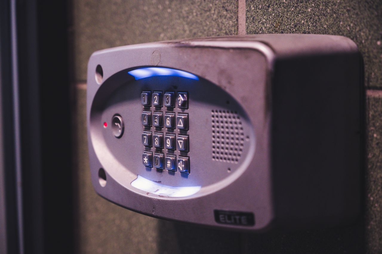 programs-02 A close-up image of an illuminated security keypad mounted on a wall.