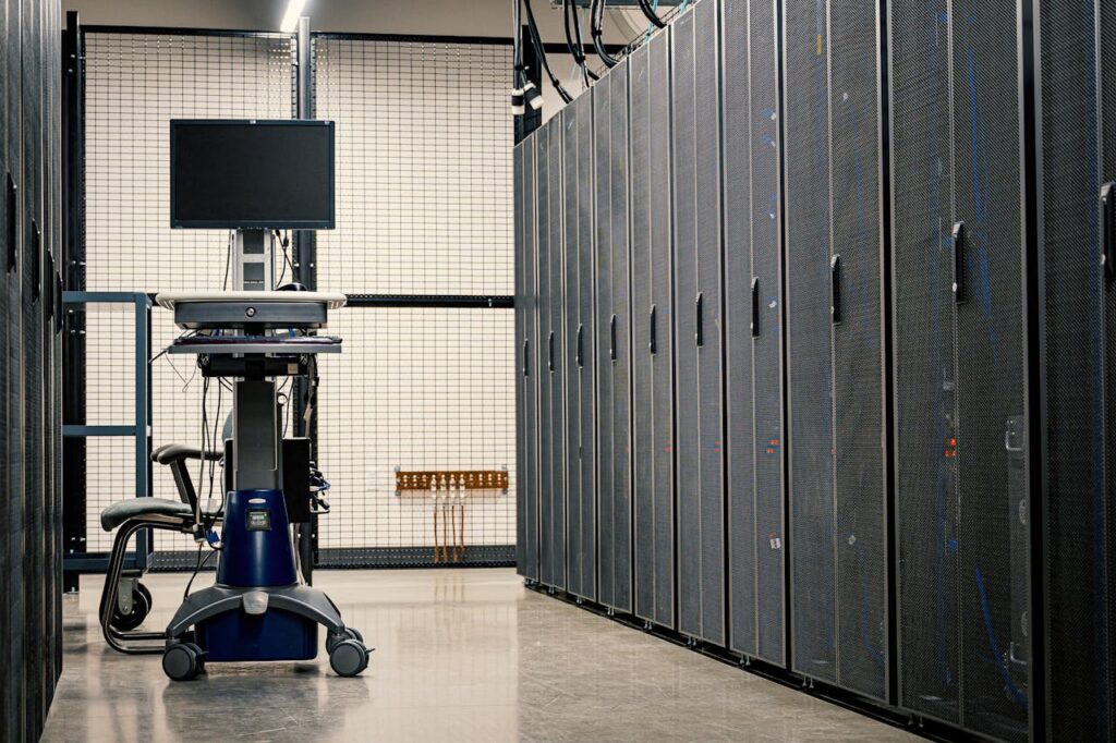 Contemporary computer on support between telecommunication racks and cabinets in modern data center